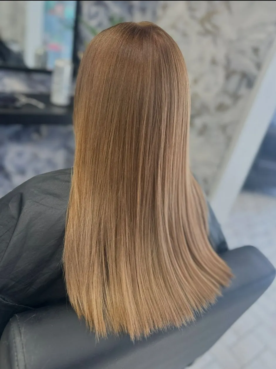Sleek straight warm caramel brown hair with a glossy finish